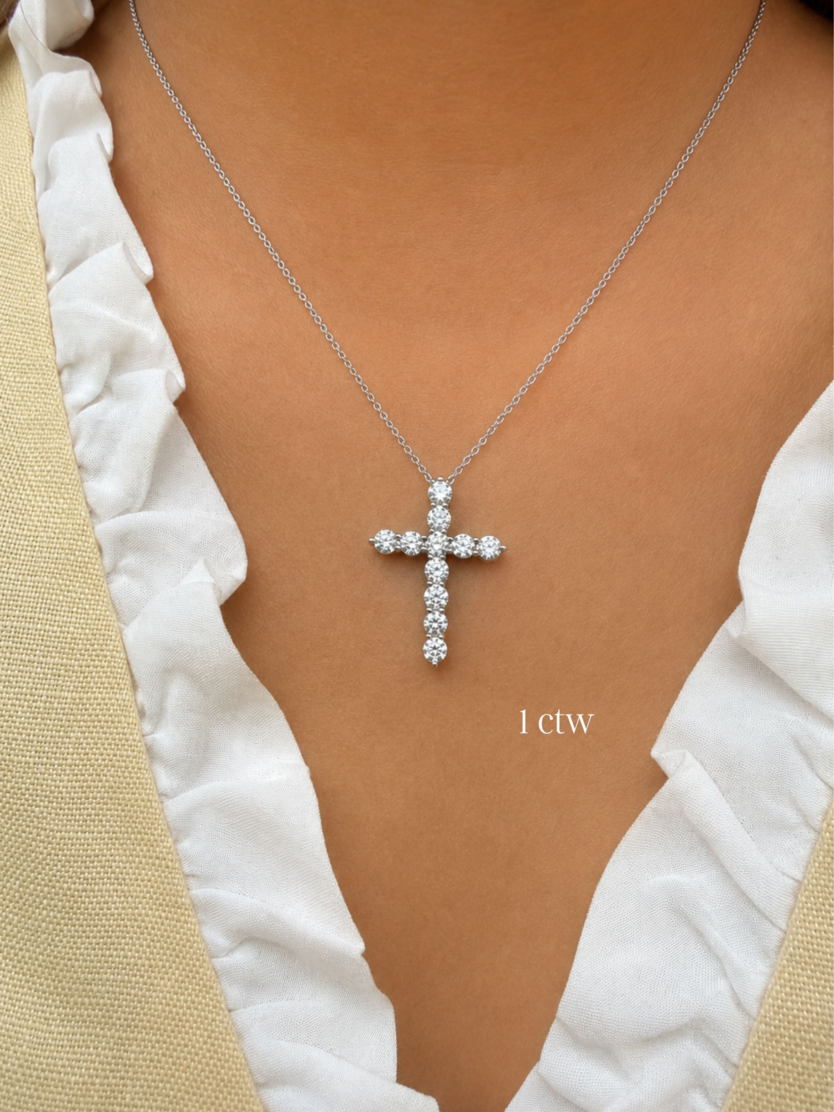 1ctw Diamond cross necklace on a person wearing a white top with beige sleeves.