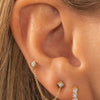 Double piercing earring with yellow gold and diamond paired with diamond huggie