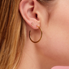 Diamond constellation earring 14K yellow gold paired with flat gold hoop on model ear