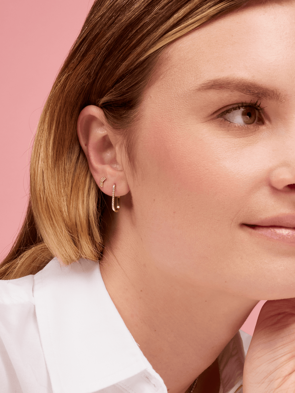 Pave Diamond Paperclip Shaped Huggie in first hole of ear and Double Chevron Pave Stud Diamond Earrings