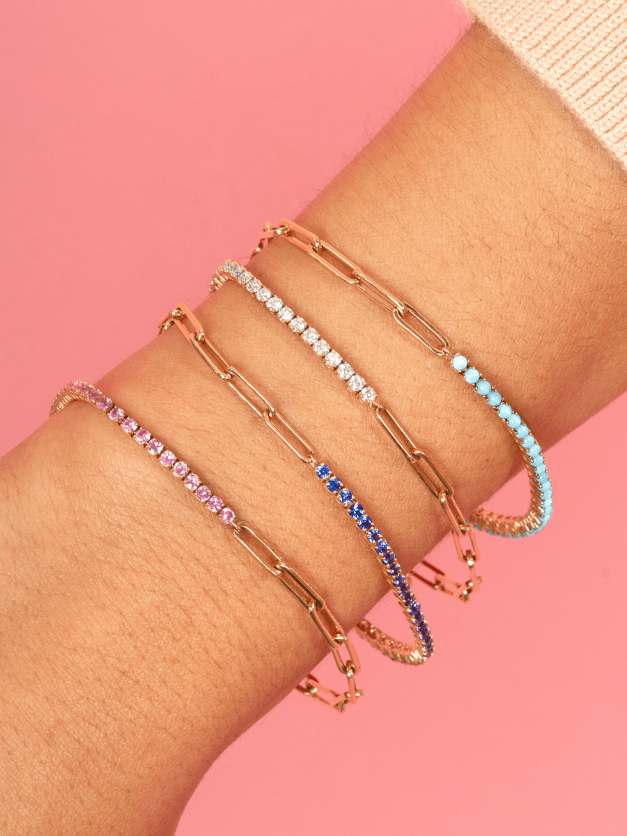 Half turquoise gold chain tennis bracelet, half diamond gold chain tennis bracelet, half blue sapphire gold chain tennis bracelet, and half pink sapphire gold chain tennis bracelet