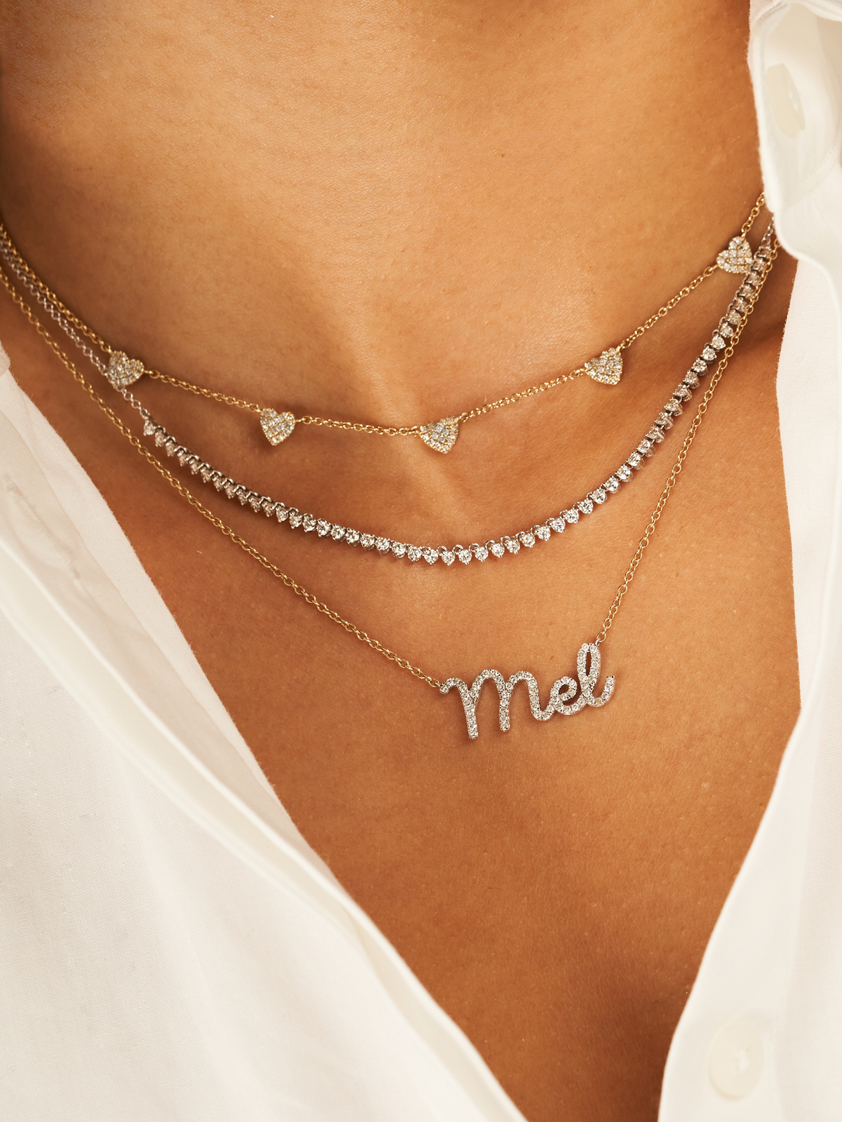 Diamond tennis chain necklace in 14K white gold layered with dainty diamond name necklace and diamond heart layering necklace