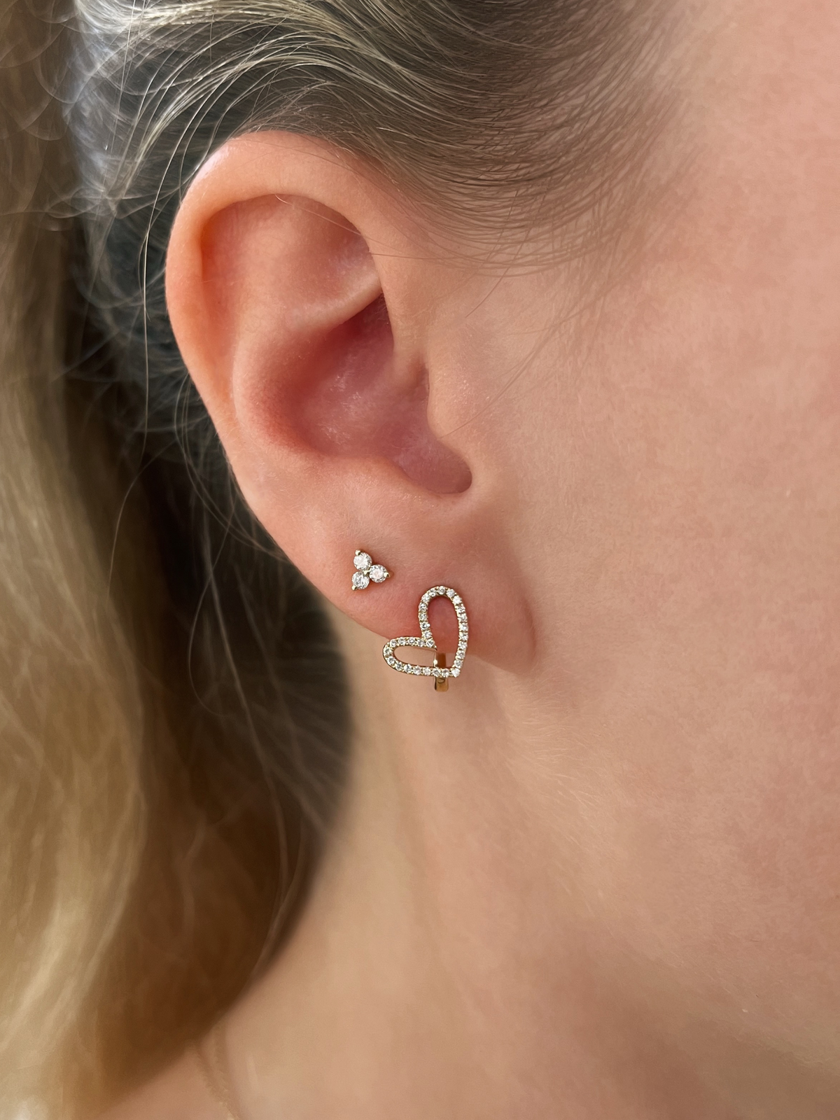Cluster diamond stud earrings paired with diamond heart huggie
