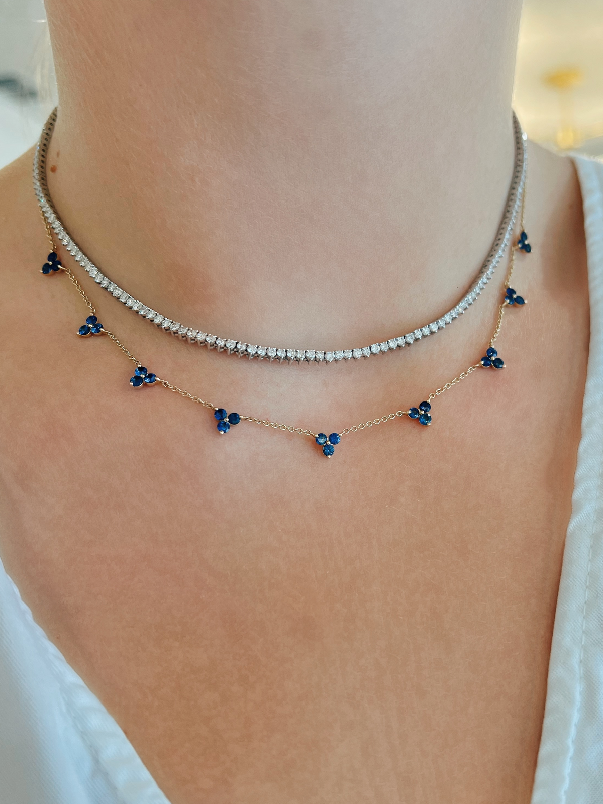 Blue sapphire necklace layered with diamond tennis necklace