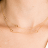 Dainty gold chain with initials and gold heart charm layered with another dainty gold chain with singular gold heart charm 