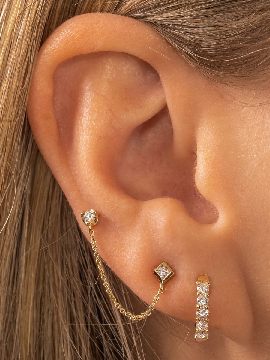 Double piercing earring with yellow gold and diamond paired with diamond huggie