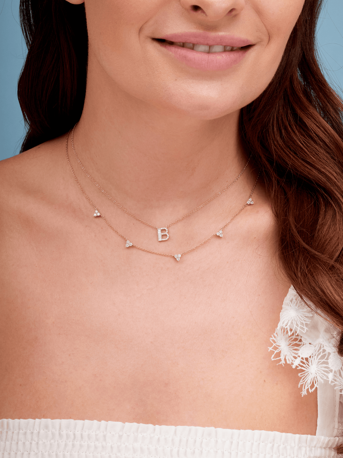 14K gold baguette diamond initial charm on dainty gold chain layered with diamond trio layering necklace in gold