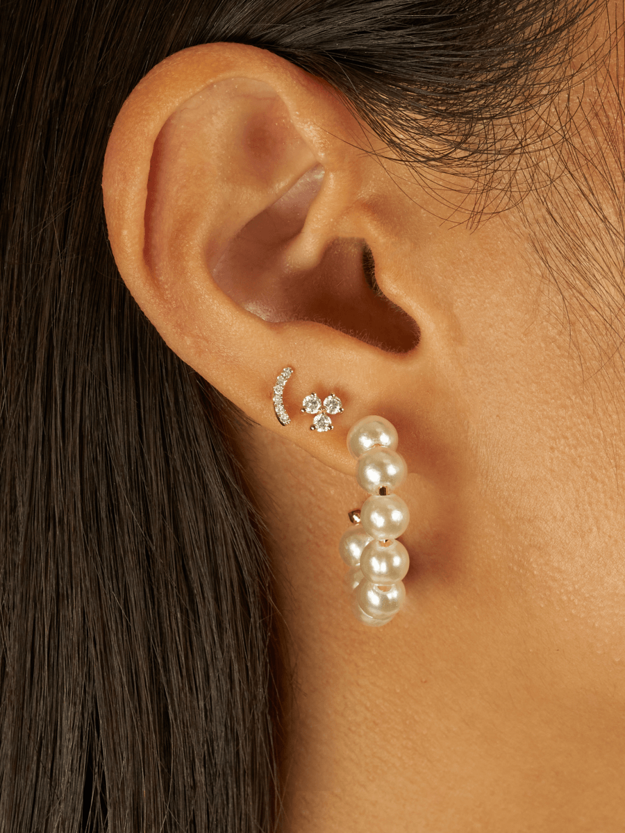 Bridge diamond earring paired with diamond trio stud and pearl hoops