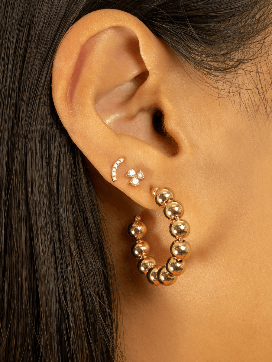 Bridge diamond earring paired with diamond trio stud and gold bead hoops