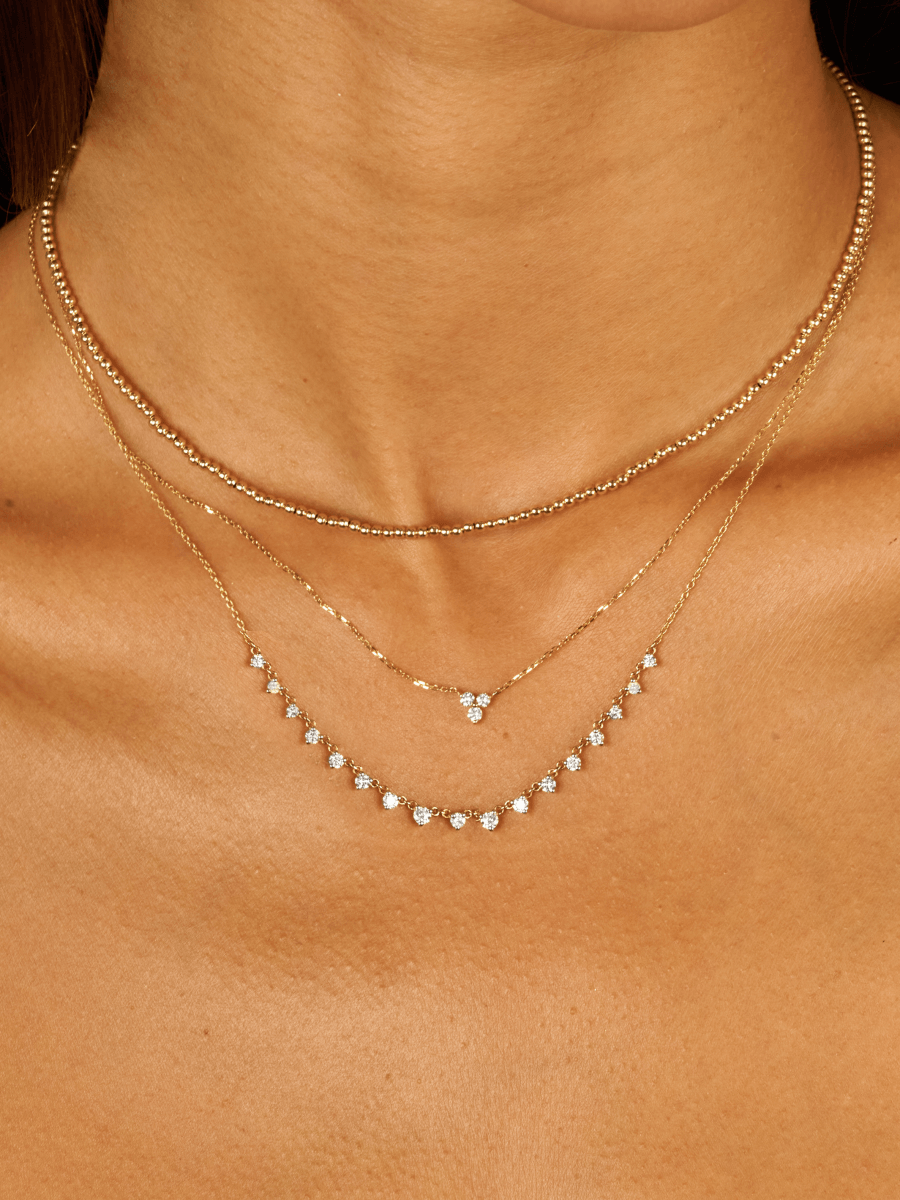 Thin gold choker layered with diamond trio necklace and graduated diamond layering necklace