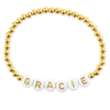 Name bracelet with gold beads on white background