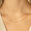 Dainty gold chain link necklace layered with floating diamond necklace