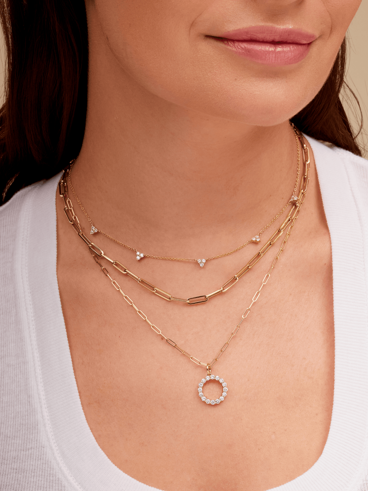 14K gold large diamond initial charm on thin gold paperlcip necklace layered with thick gold paperclip necklace and gold diamond trio layering necklace