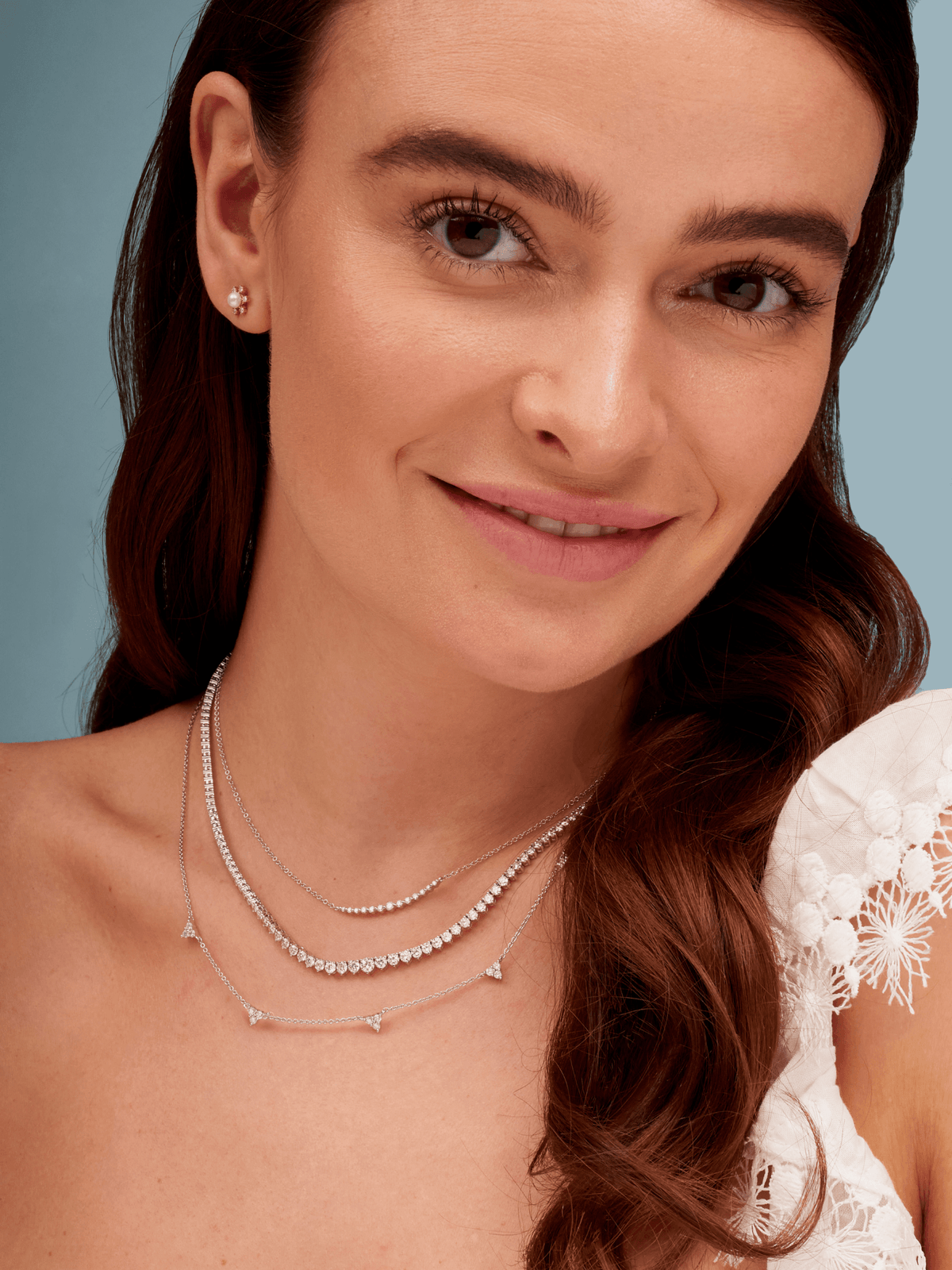 14K white gold diamond tennis necklace layered with chasing diamond necklace and diamond trio layering necklace