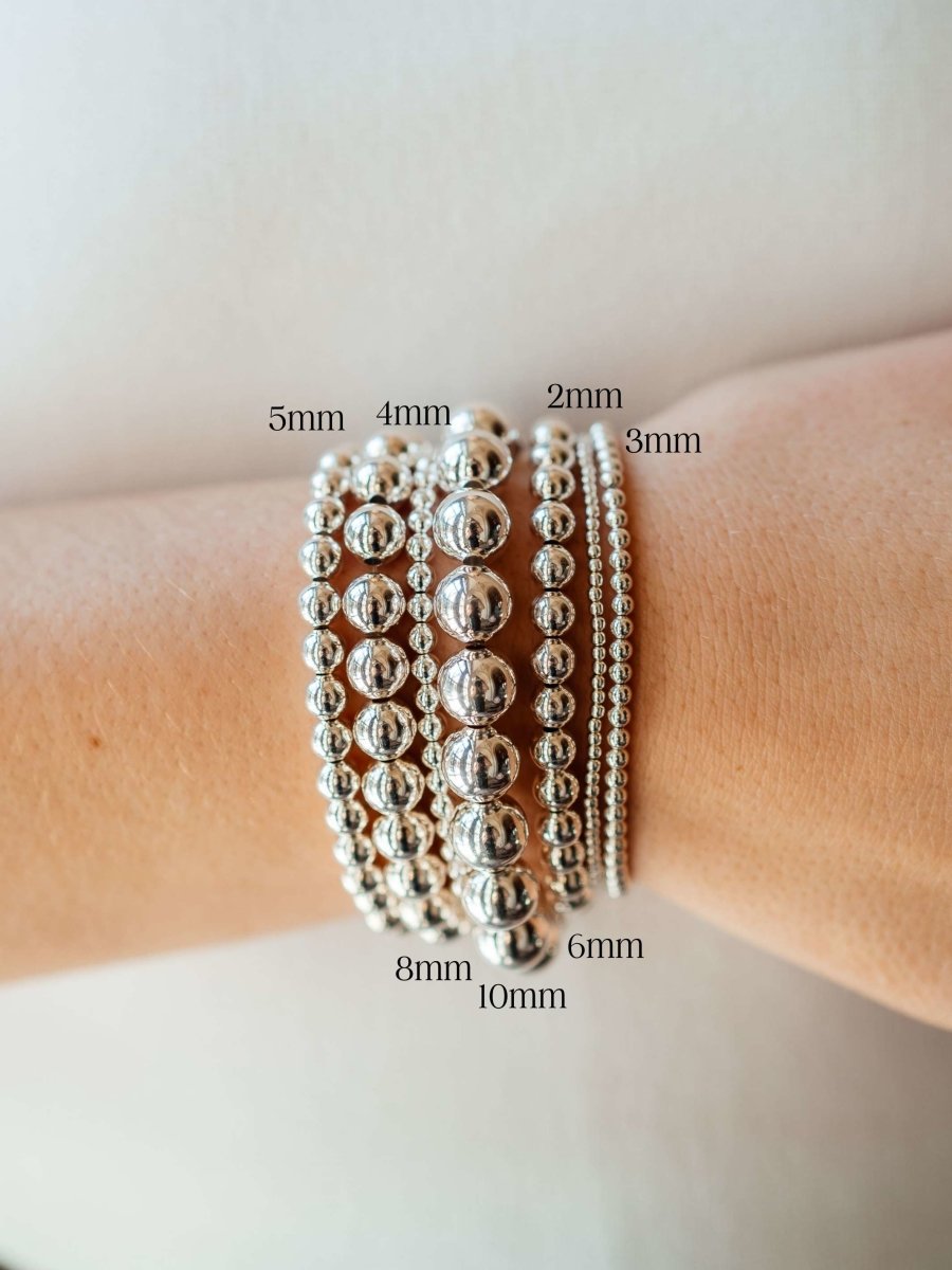 Silver stretchy beaded bracelets on model wrist