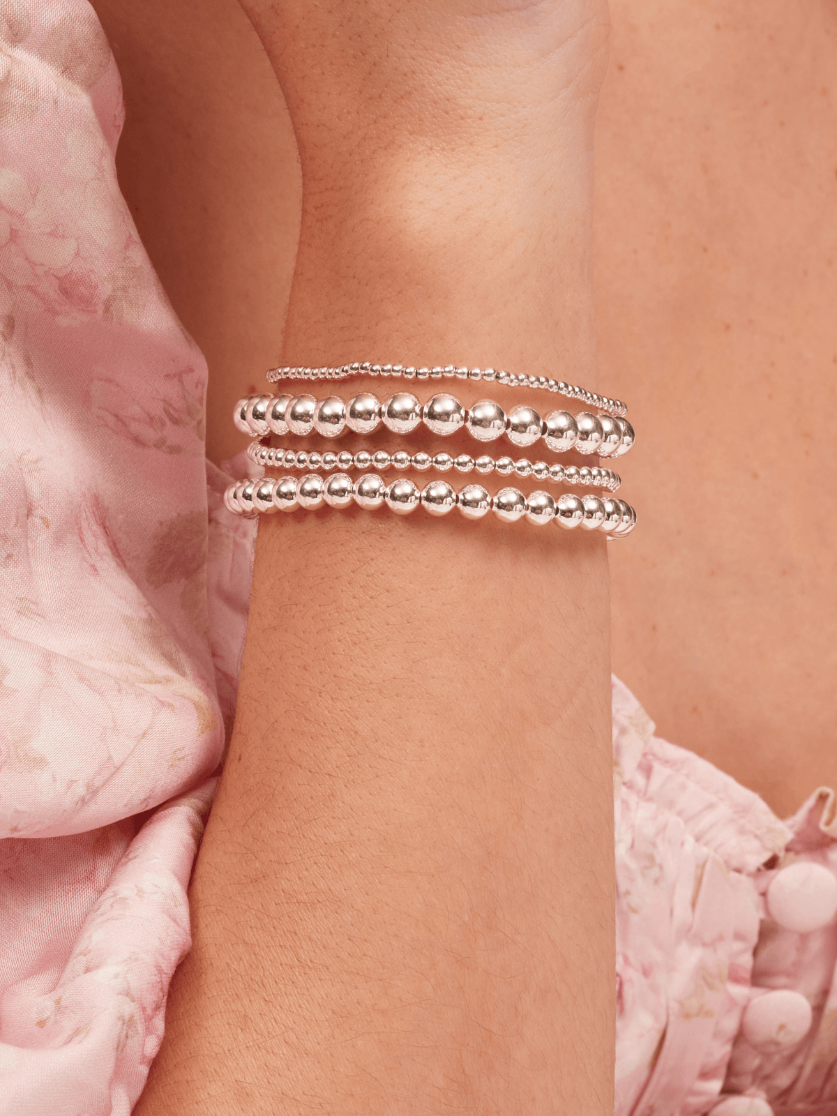 Small beaded stretch bracelets in silver on model wrist