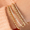 Stackable stretch bracelets gold 5mm stacked with diamond bangles on model wrist
