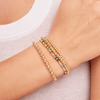 Gold beaded stretch bracelets stacked with colorful bead and gold bead stretch bracelet on model wrist