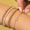 Gold beaded stretch bracelets paired with pearl stretch bracelet and mother of pearl star bracelet on model wrist