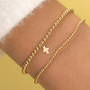 Gold beaded stretch bracelet with cross charm paired with thin gold beaded bracelet on model wrist