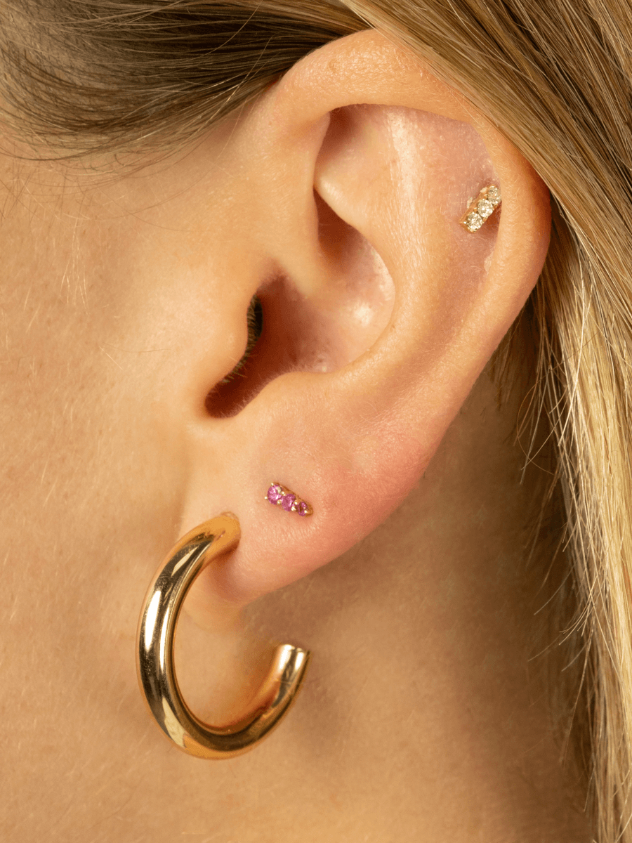Pink sapphire earrings yellow gold paired with diamond bar stud and gold chunky hoop