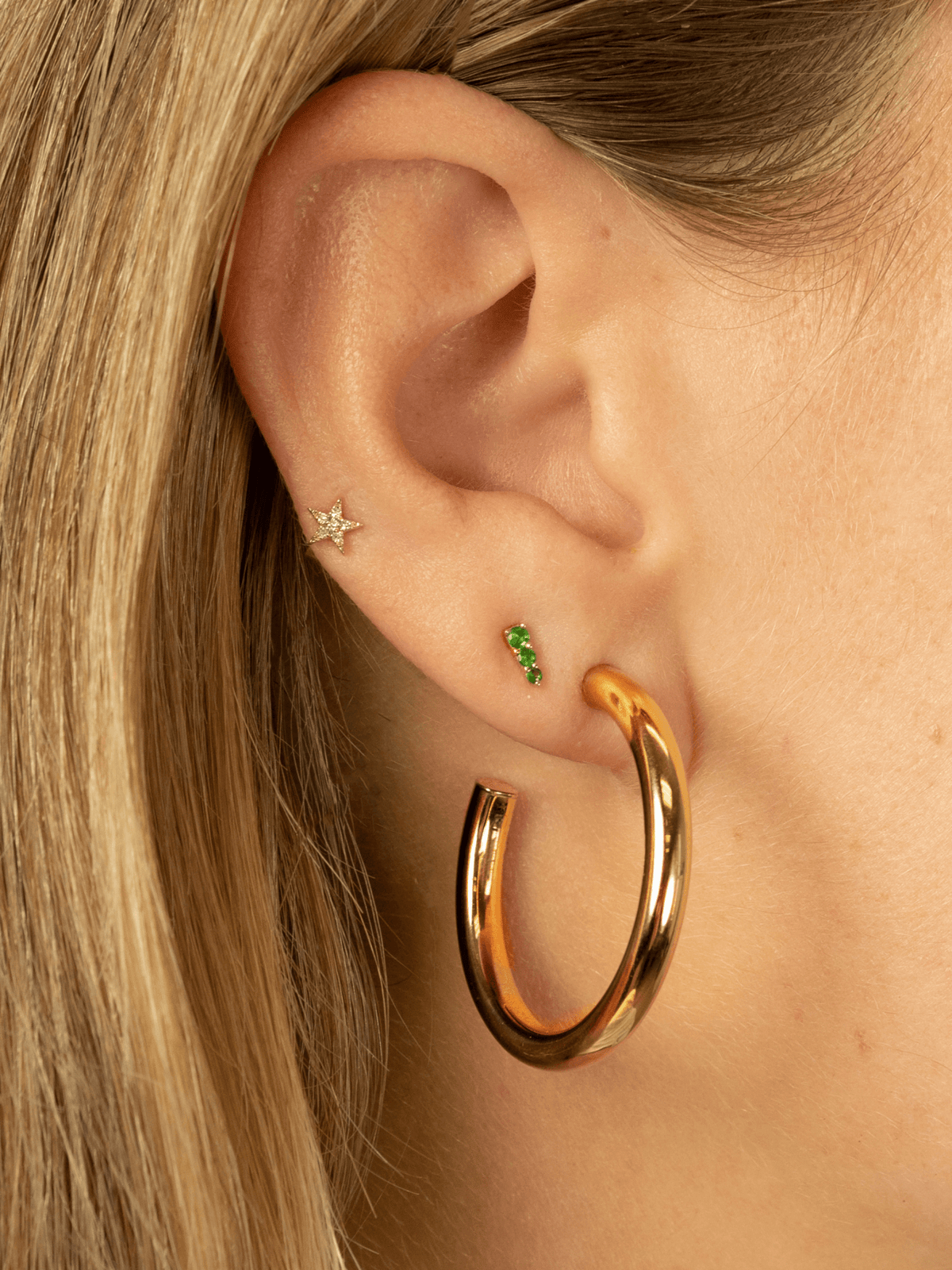 Tsavorite earrings yellow gold paired with diamond str stud and chunky gold hoop