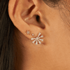 Mini gold star earring paired with diamond stud and diamond starburst stud on model ear