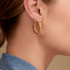 Gold star earring paired with large gold coil hoop