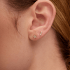 Mini gold star earring paired with diamond bar stud on model ear