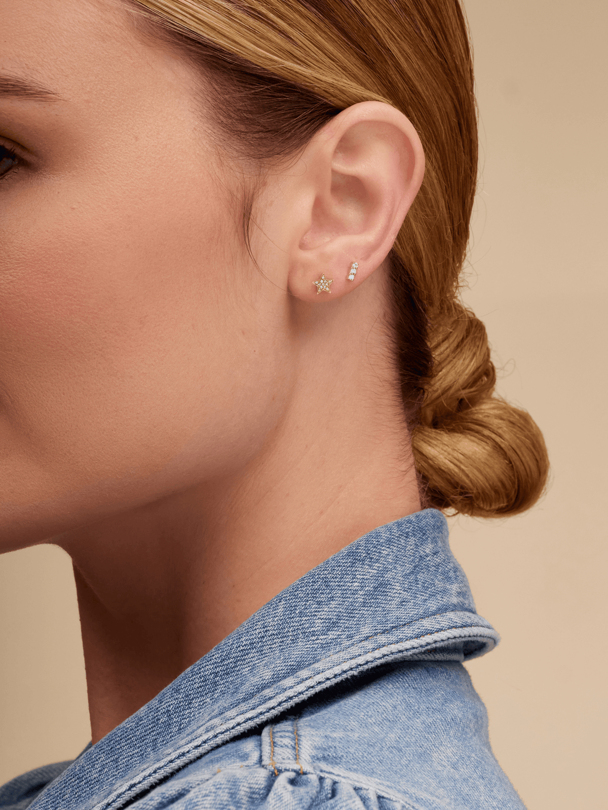 Mini gold star earring paired with diamond bar stud on model ear