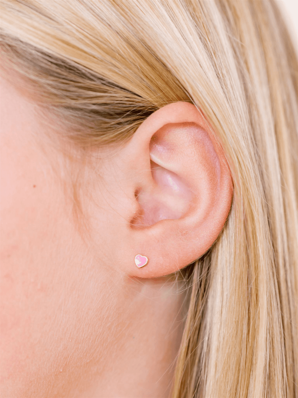 Enamel stud earring pink heart on model ear