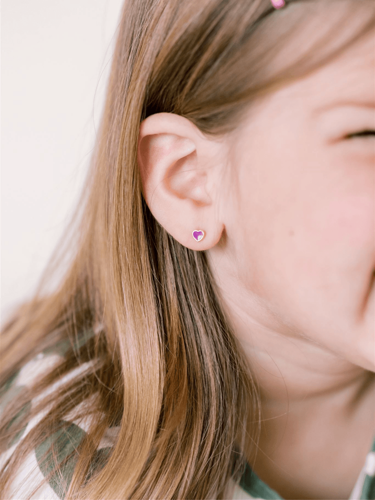 Enamel stud earring purple heart on model ear