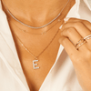 Diamond tennis chain necklace in 14K white gold layered with large diamond initial charm on paperclip chain and dainty gold initial necklace