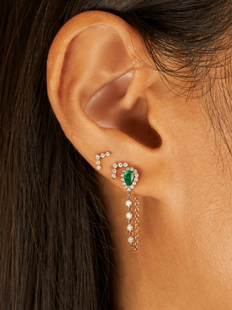 Emerald and diamond chain stud paired with diamond v earrings on model ear