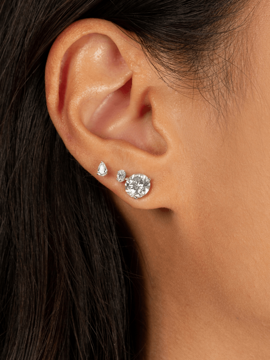 Oval stud diamond earrings paired with pear diamond studs and round diamond studs