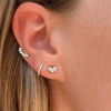Baguette diamond earrings paired with diamond huggie and diamond illusion heart stud