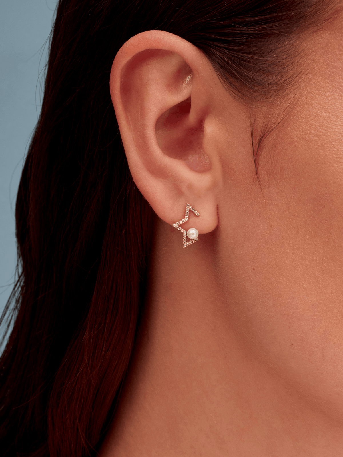 Pearl star earring with diamonds on model ear