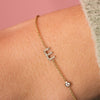 Dainty gold chain bracelet with diamond initial charm and small round diamond