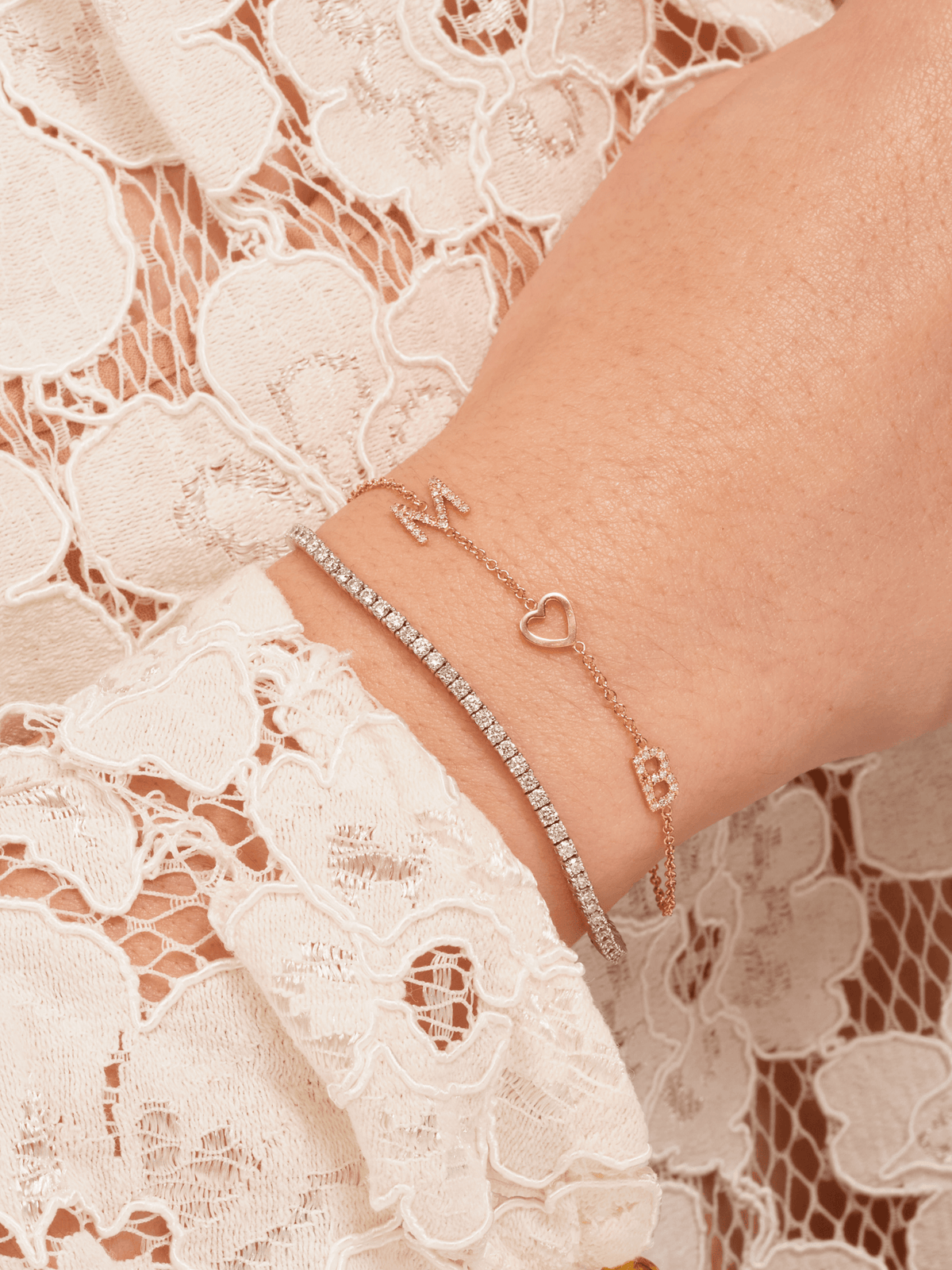 Dainty gold chain bracelet with two pave diamond initials and gold heart layered with diamond tennis bracelet