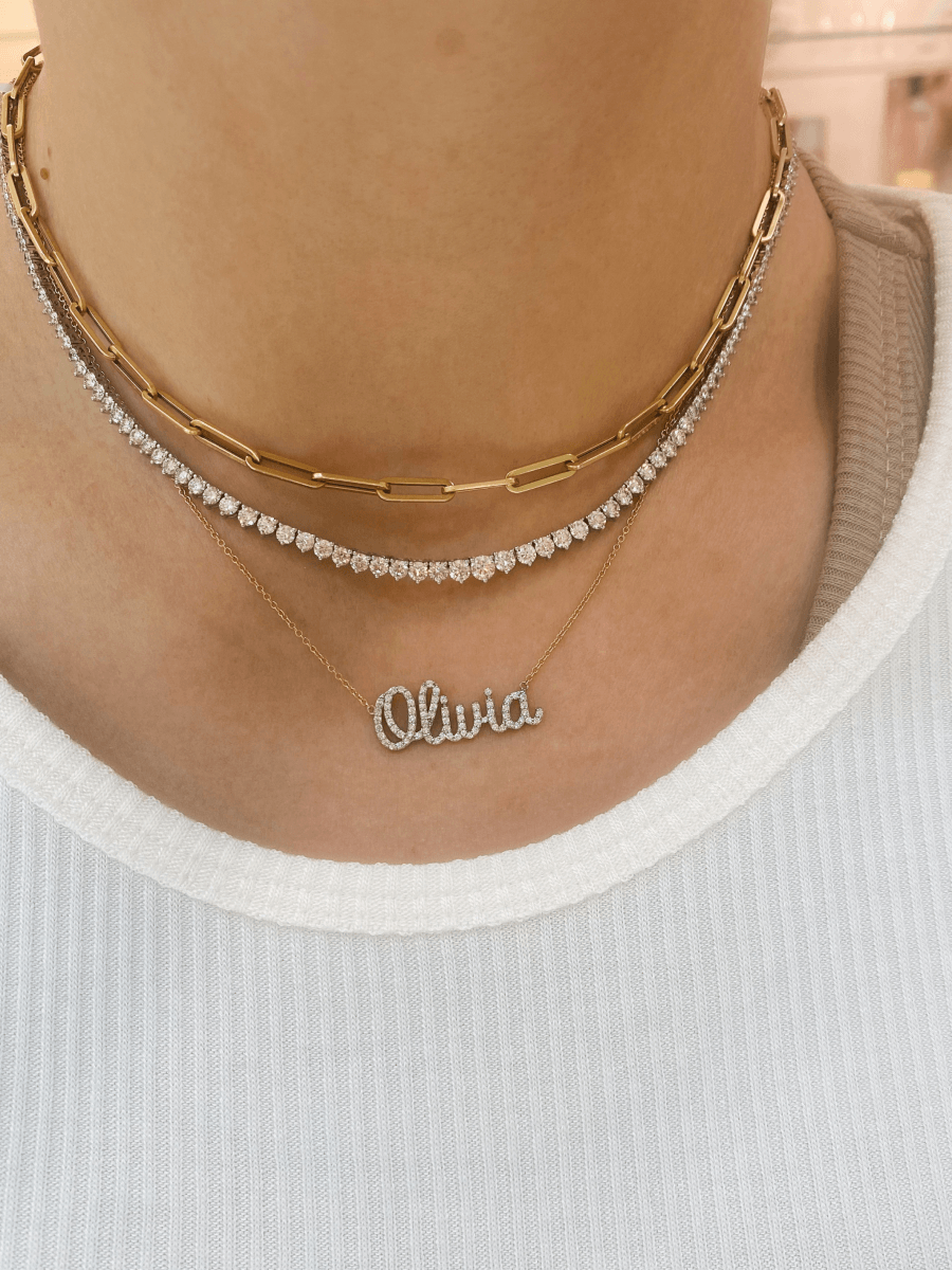 Dainty gold chain with 14K diamond name charm layered with large gold paperclip necklace and diamond tennis necklace