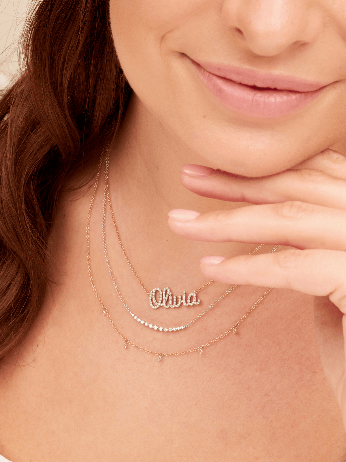 14K gold diamond name charm on dainty gold chain layered with white gold diamond chasing necklace and diamond drop layering necklace in yellow gold