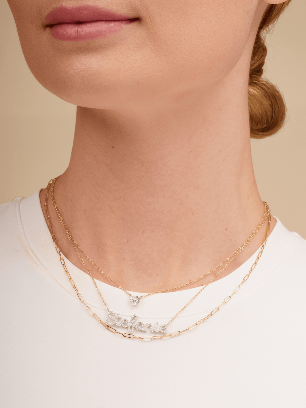 14K gold diamond name charm on dainty gold chain layered with gold paperclip necklace and dainty gold chain with diamond heart