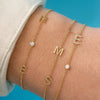 Dainty gold chain bracelet with single diamond initial and single diamond layered with dainty gold chain bracelet with three initial letters and dainty gold chain bracelet with two initial letters and single diamond