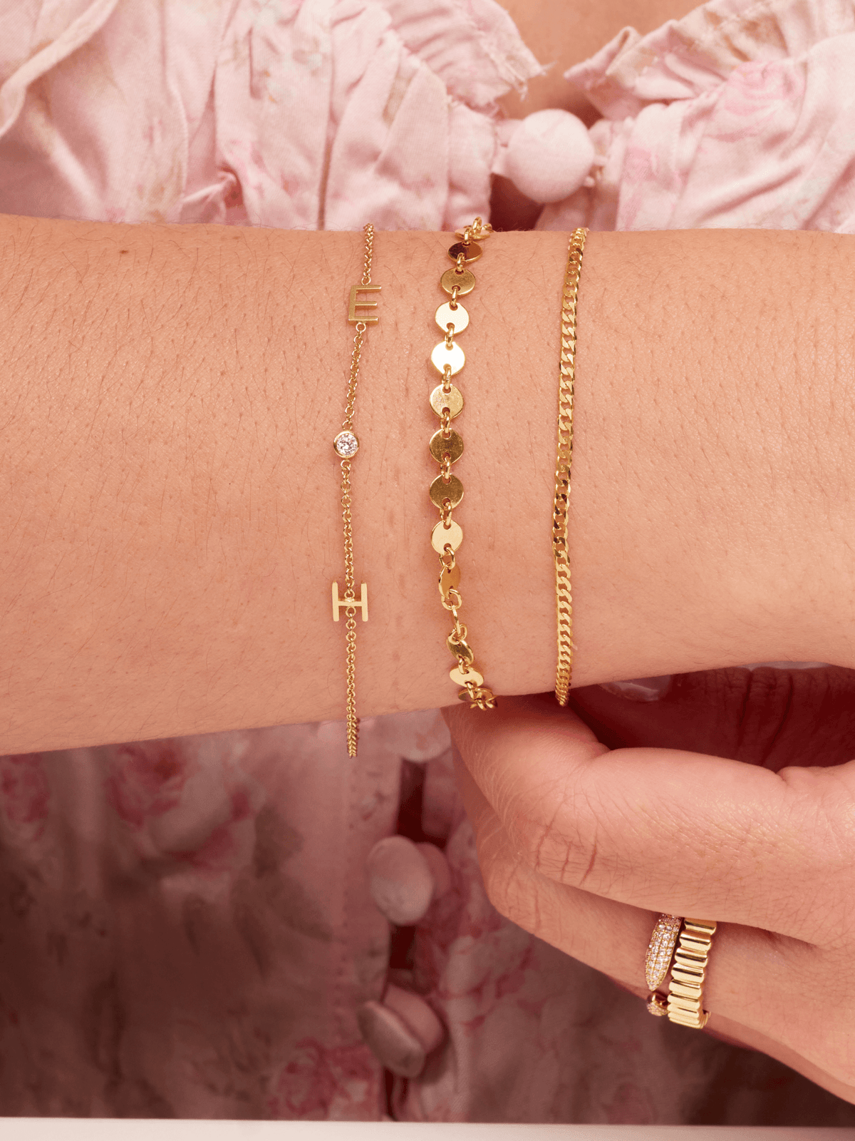 Dainty gold chain bracelet with two gold initial letters and singular diamond layered with small gold chain bracelet and valentino gold chain bracelet 