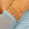 Dainty gold chain with two gold initial letters and singular diamond layered with half rolo chain and half paperclip chain bracelet and and bracelet with diamond heart on thick gold chain