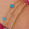 Dainty gold chain bracelet with three initials layered with gold beaded bracelet and bracelet with turquoise hearts on simple gold chain