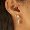 Cluster diamond earring paired with bridge diamond earring and pearl hoop